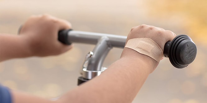 Hand op stuur van fiets met Nexcare™ DUO-pleister
