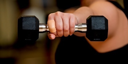 Active Tape op de vinger van de persoon die de halter optilt
