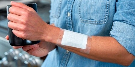Universele tape die een verband op iemands hand fixeert
