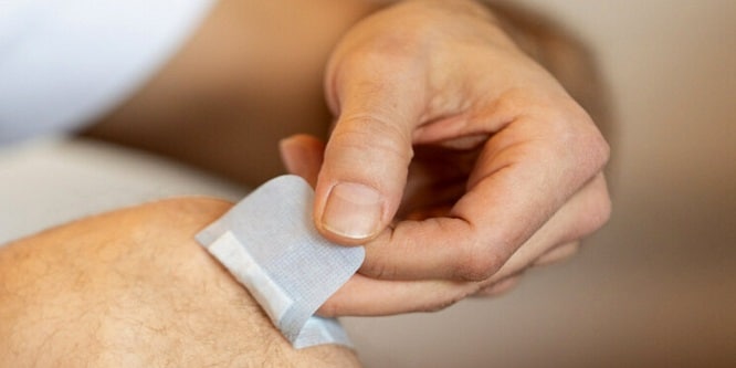 Man die de Nexcare-pleister verwijdert
