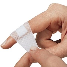 vrouw doet pleister om haar vinger
